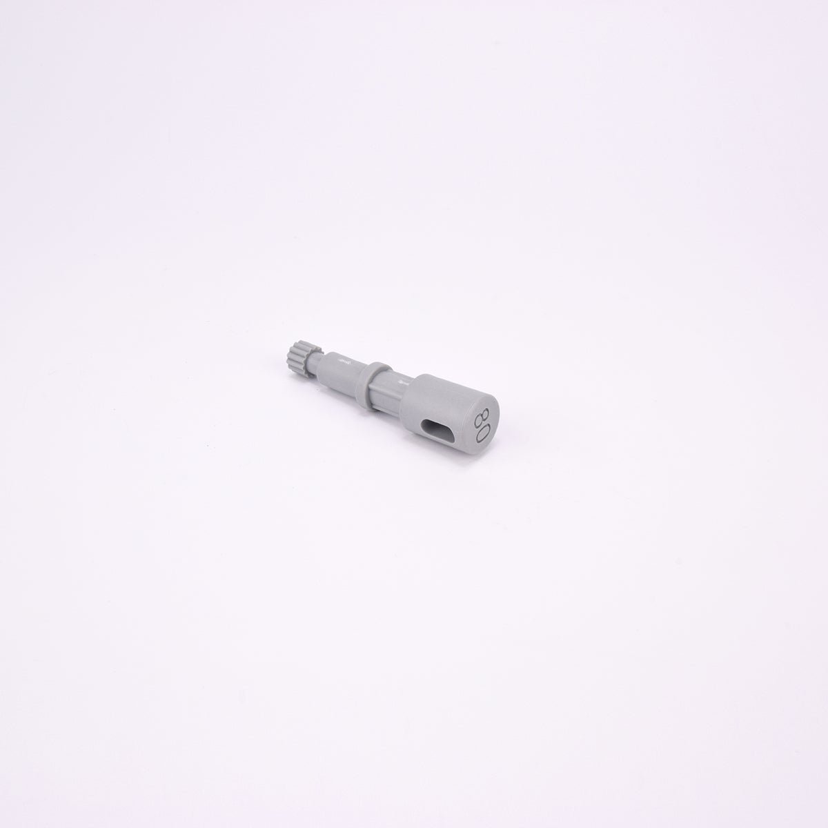 Grå användarpegg med cylindrisk form och flera sektioner med olika diameter. Ena änden är ihålig med ett avlångt spår, medan den motsatta änden har en räfflad yta.
