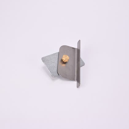 Två metall föremål med vinklad kant, fästa med guldfärgad skruv.