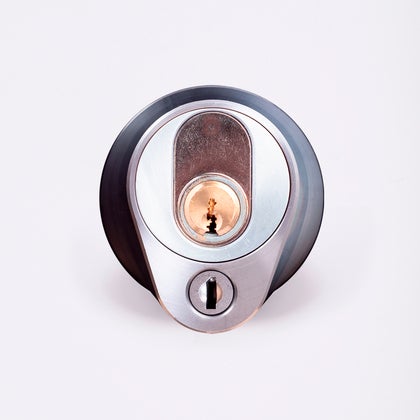 Närbild av ett silverfärgat säkerhetslås med två nyckelhål, placerade ovanför varandra.