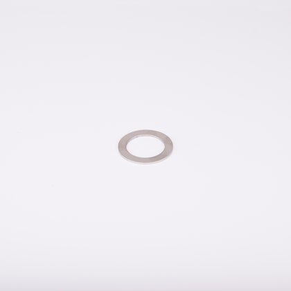 En distansbricka i metall med cirkulär form och ett centralt hål.