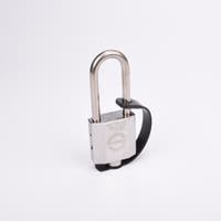 Silverfärgat hänglås med rektangulär kropp och rund bygel. En svart gummirem är fäst från hänglåsets nedre del till bygeln.