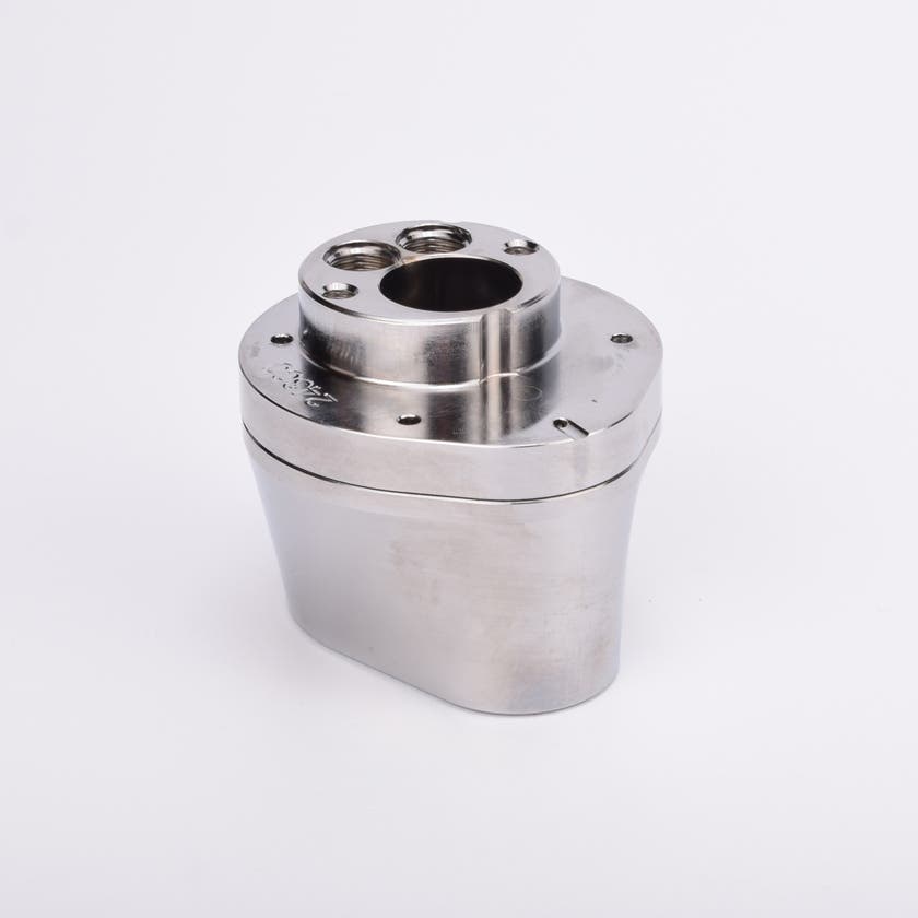 Silverfärgad metallkropp med rundad bas och flera hål på ovansidan.