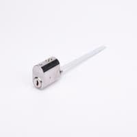 Oval låscylinder i silverfärgad metall med en lång, platt, räfflad medbringare i metall.