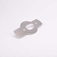 Monterningsplåt med rektangulära utskott på båda sidor av en central cirkelsektion med ovalt urtag och två sexkantiga hål.