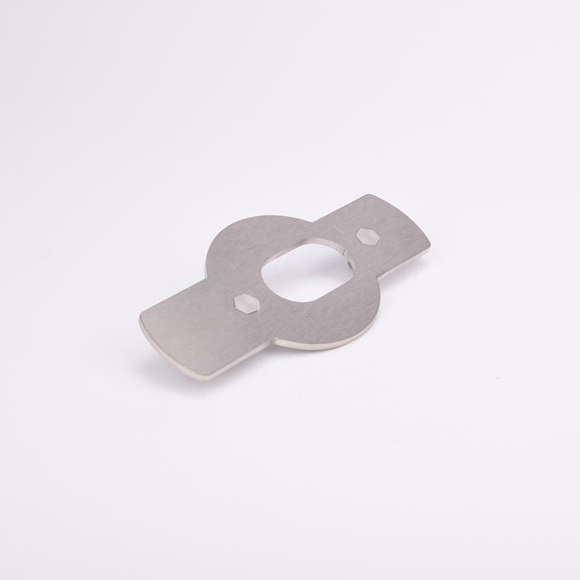 Monterningsplåt med rektangulära utskott på båda sidor av en central cirkelsektion med ovalt urtag och två sexkantiga hål.