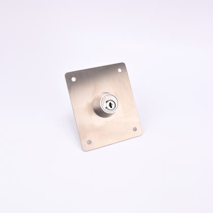 En rektangulär metallplatta med ett cylinderlås i mitten och fyra hål i hörnen.