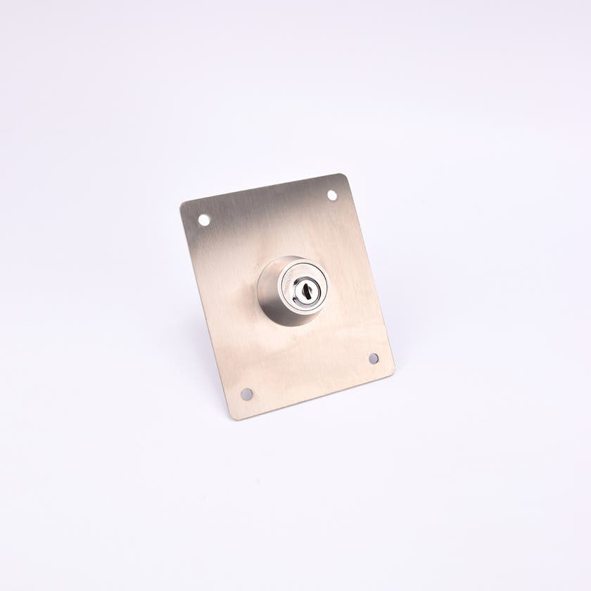 En rektangulär metallplatta med ett cylinderlås i mitten och fyra hål i hörnen.