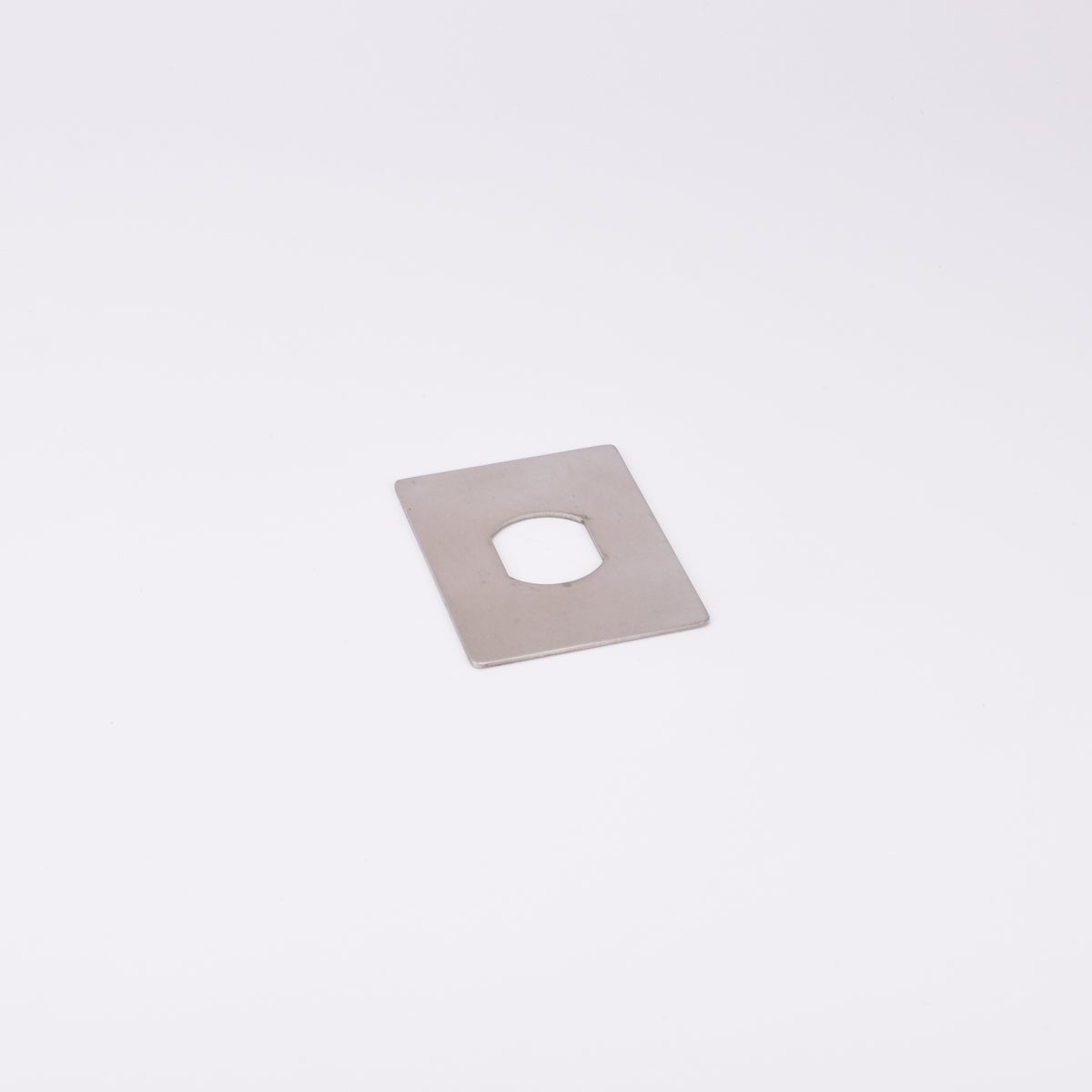 En rektangulär metallplatta med hål i mitten.