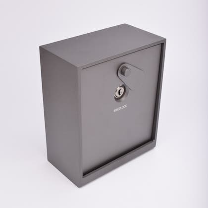 Grått fasadnyckelskåp i metall med vridbar skyddskåpa.