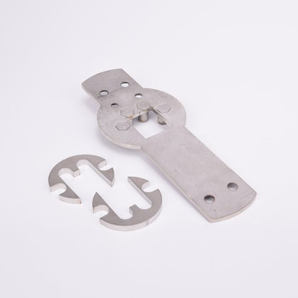 Tre metallkomponenter: en rektangulär platta med hål och utskärningar samt två halvcirkelformade delar med krokformade utskärningar.