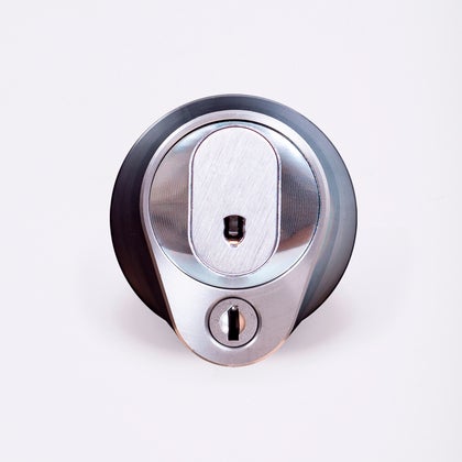 Närbild av ett silverfärgat säkerhetslås med två nyckelhål, placerade ovanför varandra.