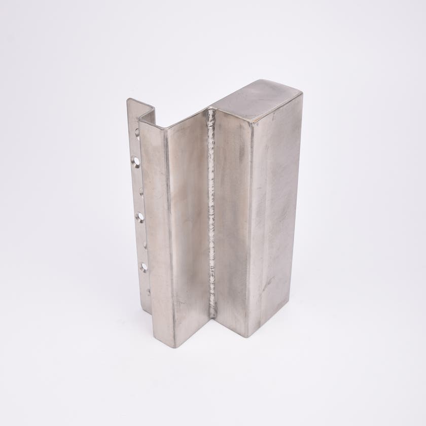 En L-formad nyckelförvaringsenhet med flera cirkulära hål längs ena sidan.