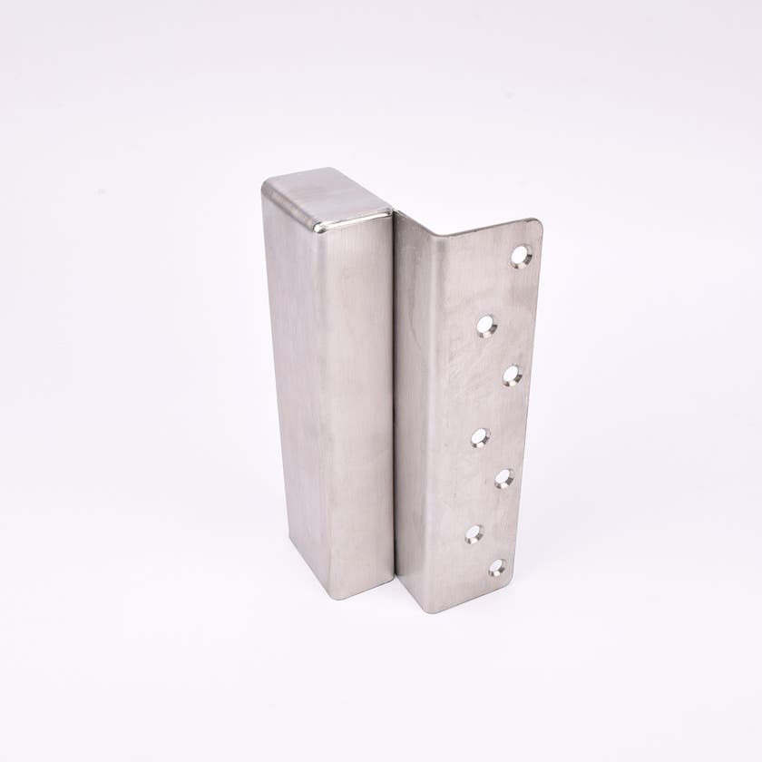 En L-formad nyckelförvaringsenhet med flera cirkulära hål längs ena sidan.