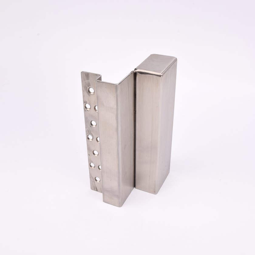 En L-formad nyckelförvaringsenhet med flera cirkulära hål längs ena sidan.