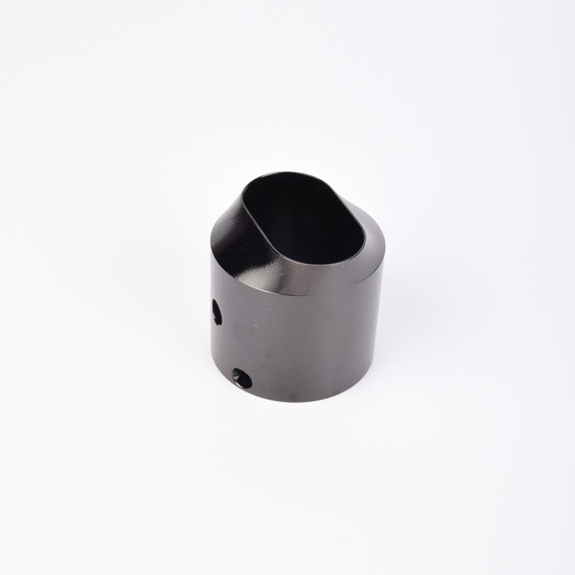 Svart utfyllnadsadapter i metall med snedskuren topp som bildar en oval öppning.