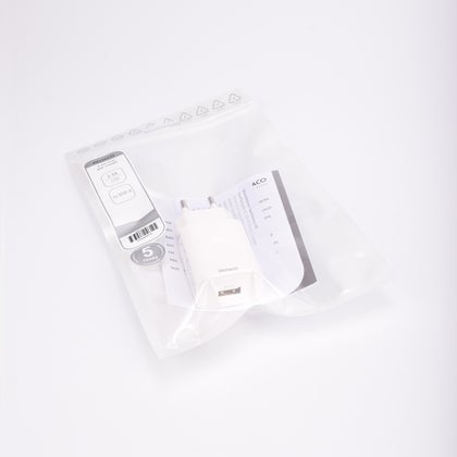 Vit USB-väggladdare, 230V till USB, förpackad i transparent plastpåse med etikett och bruksanvisning.