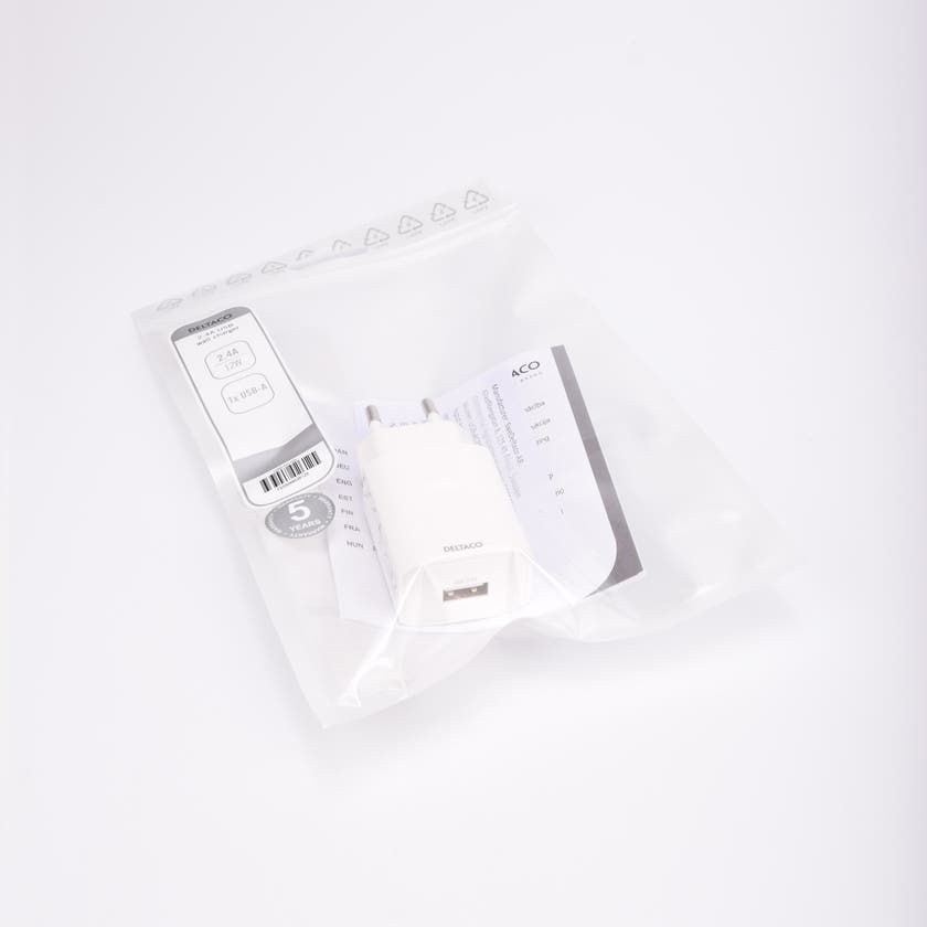 Vit USB-väggladdare, 230V till USB, förpackad i transparent plastpåse med etikett och bruksanvisning.