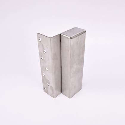 En L-formad nyckelförvaringsenhet med flera cirkulära hål längs ena sidan.