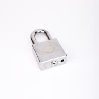 Silverfärgat hänglås med rektangulär kropp och rund bygel.