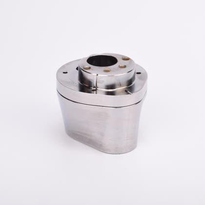 Silverfärgad metallkropp med rundad bas och flera hål på ovansidan.