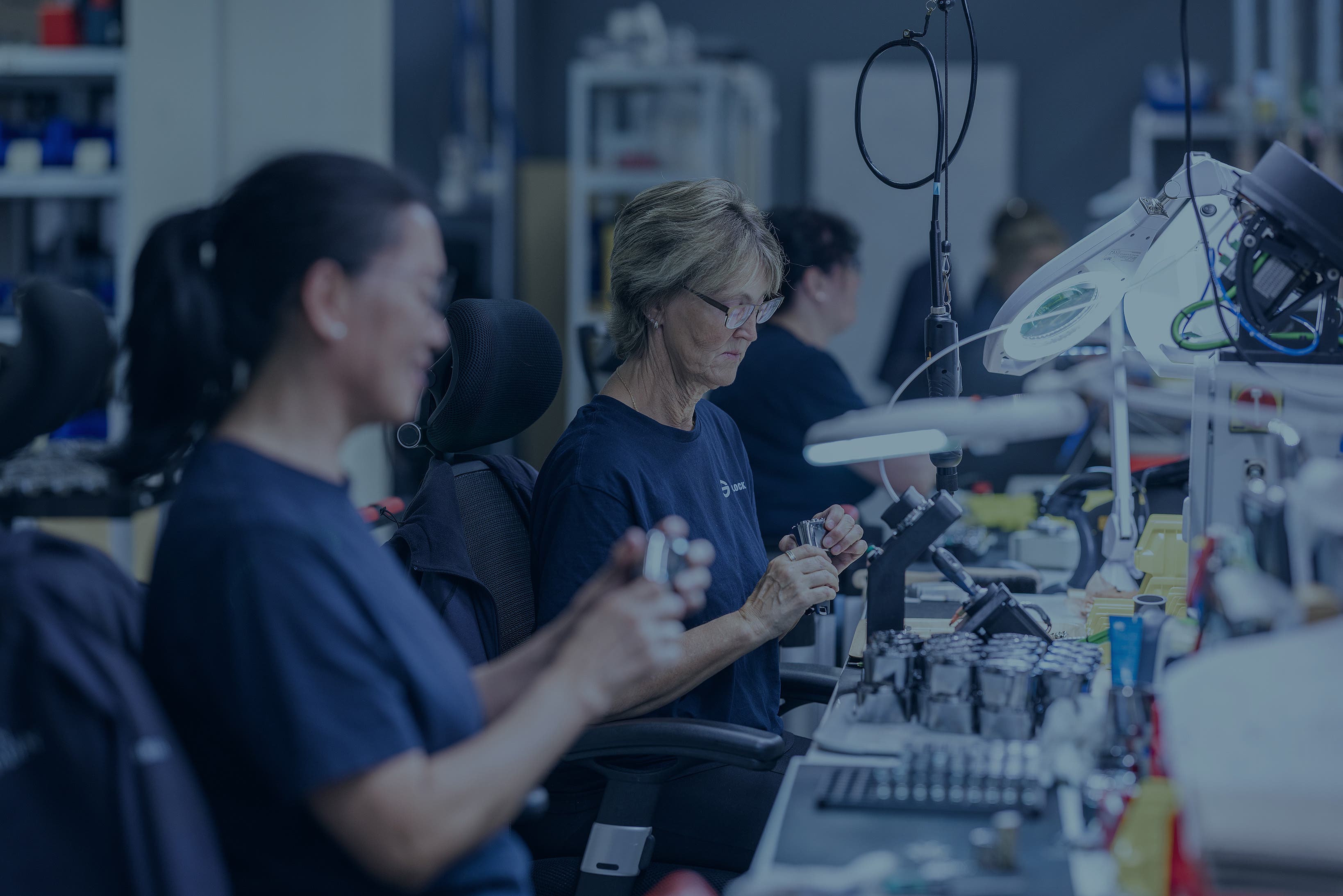 Kvinner som sitter ved et skrivebord og monterer lås