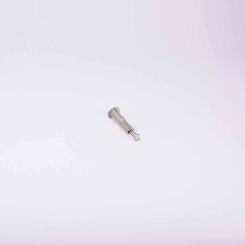 En metallisk cylinderformad komponent med en fjäder som sticker ut från ena änden.