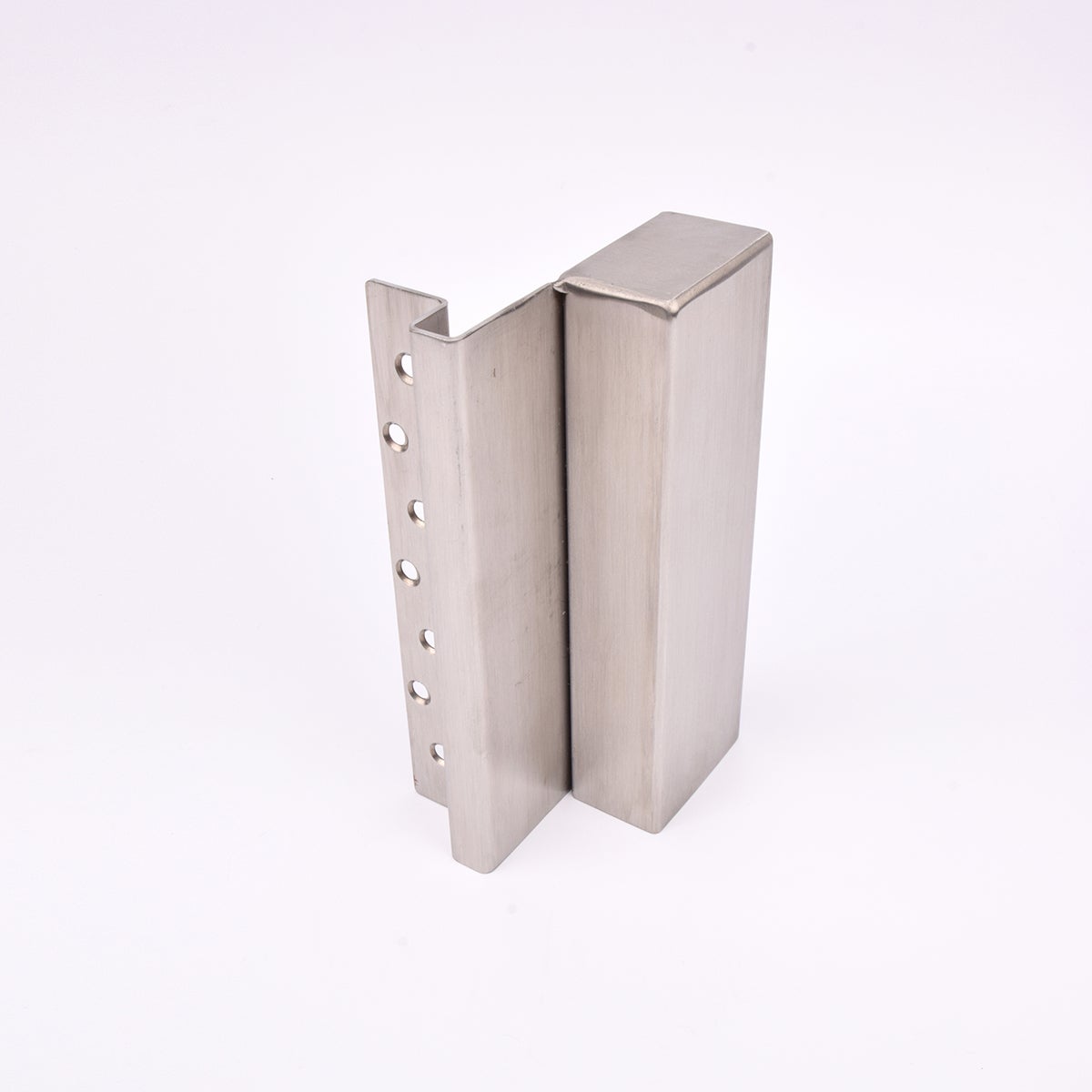 En L-formad nyckelförvaringsenhet med flera cirkulära hål längs ena sidan. 
