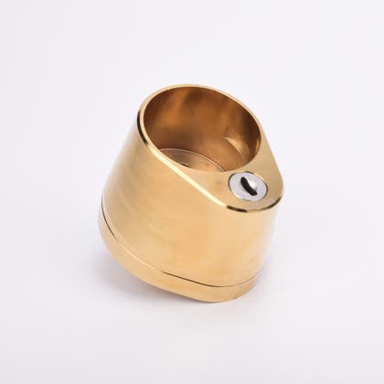 Droppformat mässingslås med rundformat urtag för låscylinder, samt nyckelhål i nedre delen.