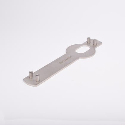 Monteringsplåt avlång, platt kropp och ovalt urtag i mitten samt fyra vertikala cylindriska tappar, två i vardera ände.