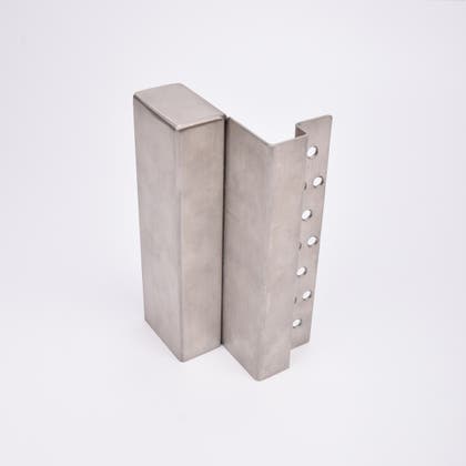 En L-formad nyckelförvaringsenhet med flera cirkulära hål längs ena sidan.