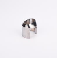 Polerad metallkomponent med cylindrisk form, vinklad topp och två ovala utskärningar.