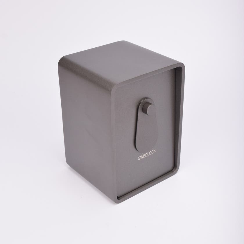 Grått fasadnyckelskåp i metall med rundade hörn och vridbar skyddskåpa.