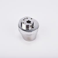 Silverfärgad metallkropp med rundad bas och flera hål på ovansidan.