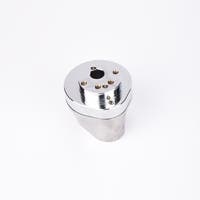 Silverfärgad metallkropp med rundad bas och flera hål på ovansidan.