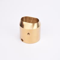 Mässingsfärgat utfyllnadsadapter i metall med snedskuren topp som bildar en oval öppning.