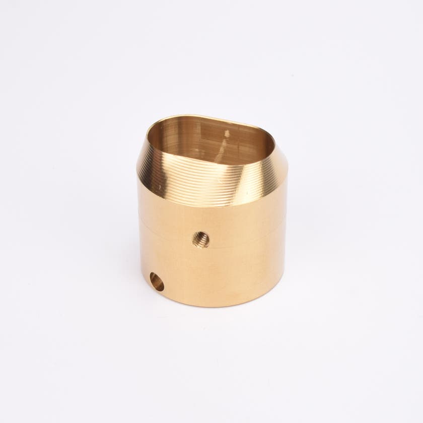 Mässingsfärgat utfyllnadsadapter i metall med snedskuren topp som bildar en oval öppning.