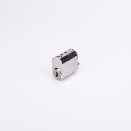 Liten cylindrisk låskolv i metall med blank yta.