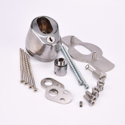 Droppformad låscylinder med ovalt urtag, samt nyckelhål och monteringssats med metallkomponenter för montering, inklusive skruvar, muttrar och brickor.