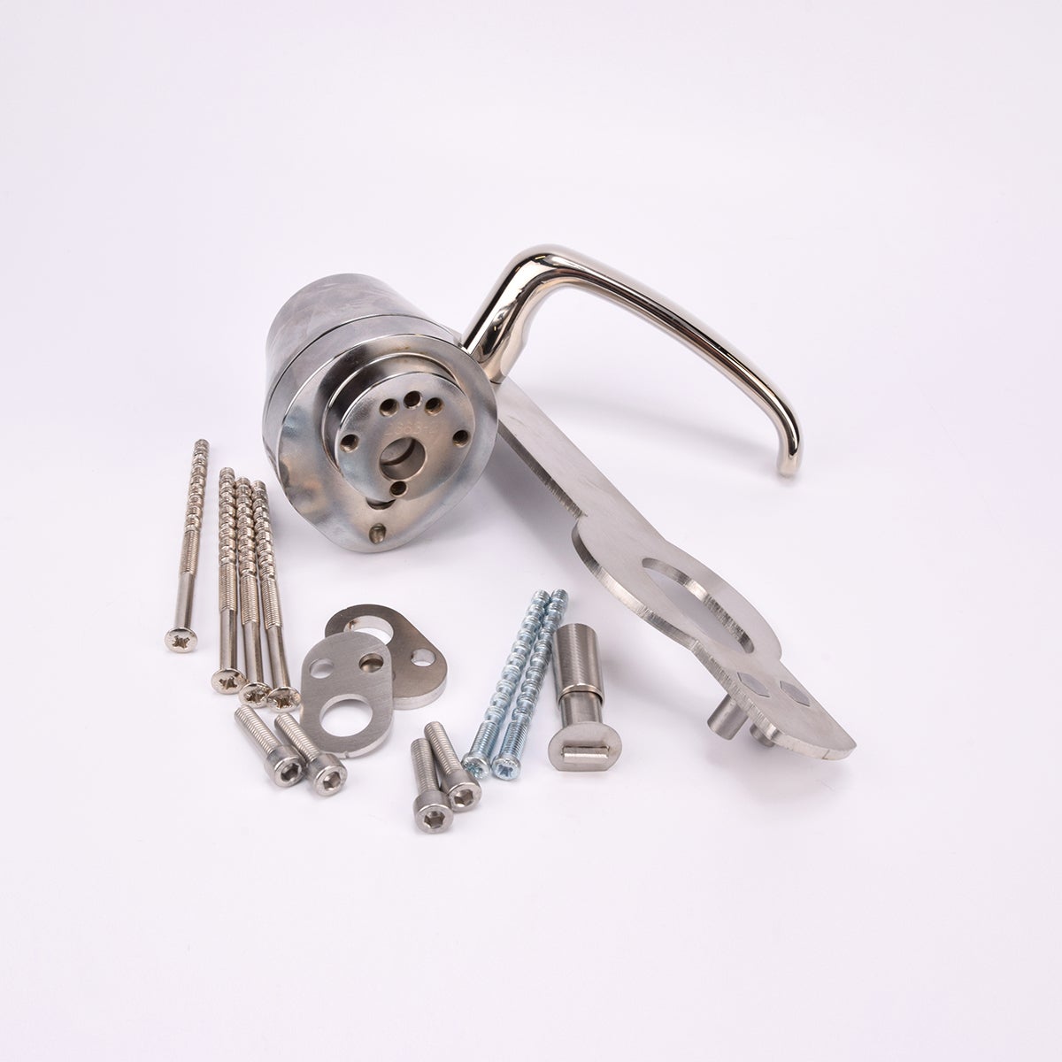 Ett dörrhandtag i metall fäst på en rektangulär metallplatta med tillhörande låscylinder och flera olika skruvar och beslag.