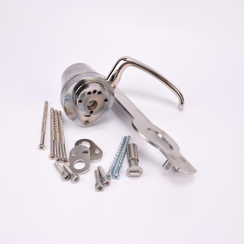 Ett dörrhandtag i metall fäst på en rektangulär metallplatta med tillhörande låscylinder och flera olika skruvar och beslag.