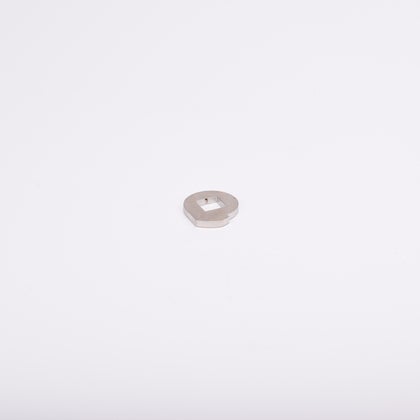 Metallbricka med cirkulär form och fyrkantigt hål i mitten.