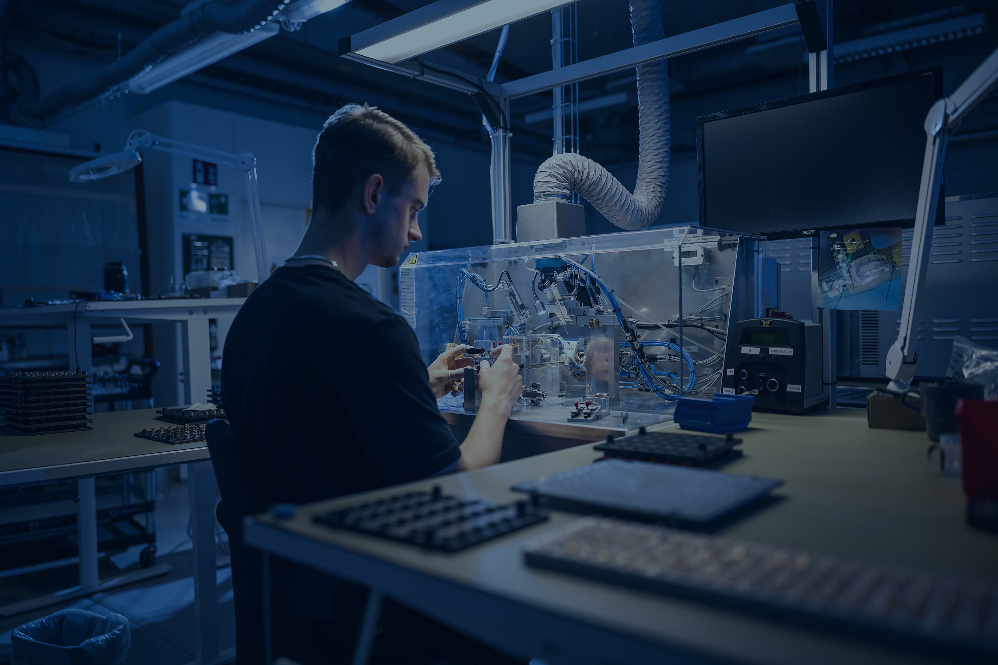 En mann som sitter ved et skrivebord og monterer lås