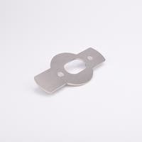 Monterningsplåt med rektangulära utskott på båda sidor av en central cirkelsektion med ovalt urtag och två sexkantiga hål.