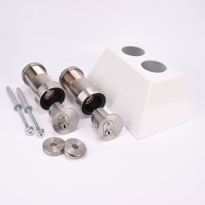 Två cylinderformade rör med två cylindriska lås i rostfritt stål, två skruvar, två runda metallbrickor och ett vitt trapphusfäste i metall med två hål.
